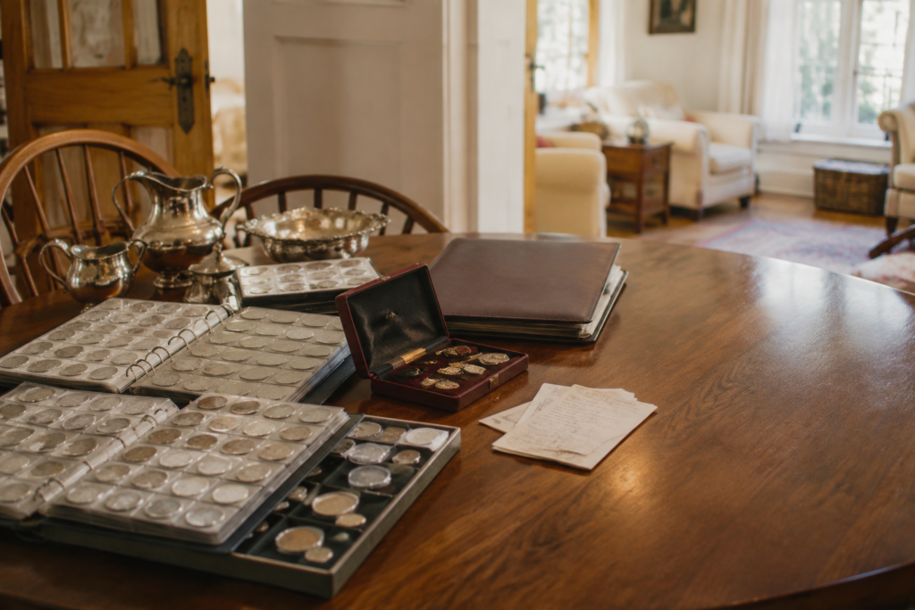 Inherited coin albums, jewelry, and sterling pieces arranged for an on-site collection review.